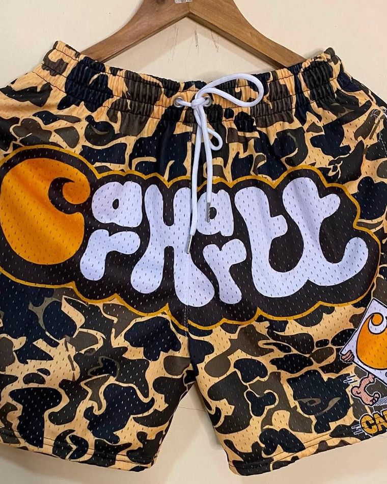 Tan camo mesh shorts with a front graphic